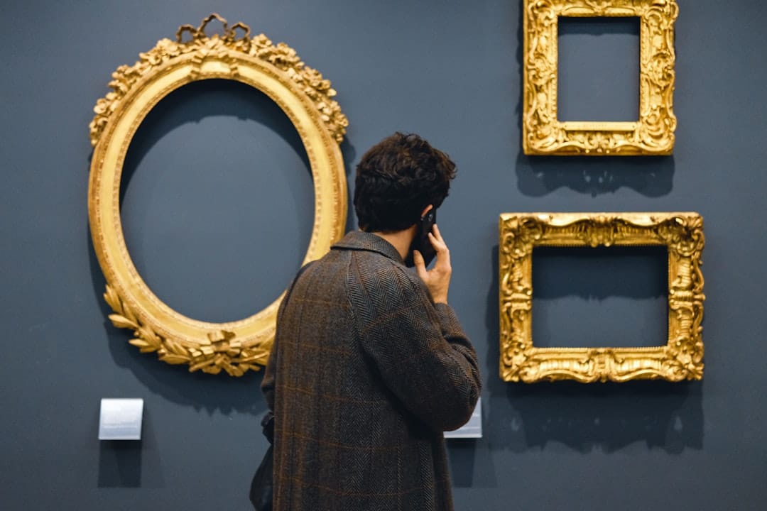 man in black jacket standing in front of brown wooden frames