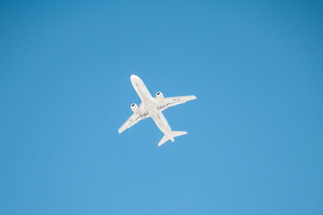 white airplane in mid air during daytime
